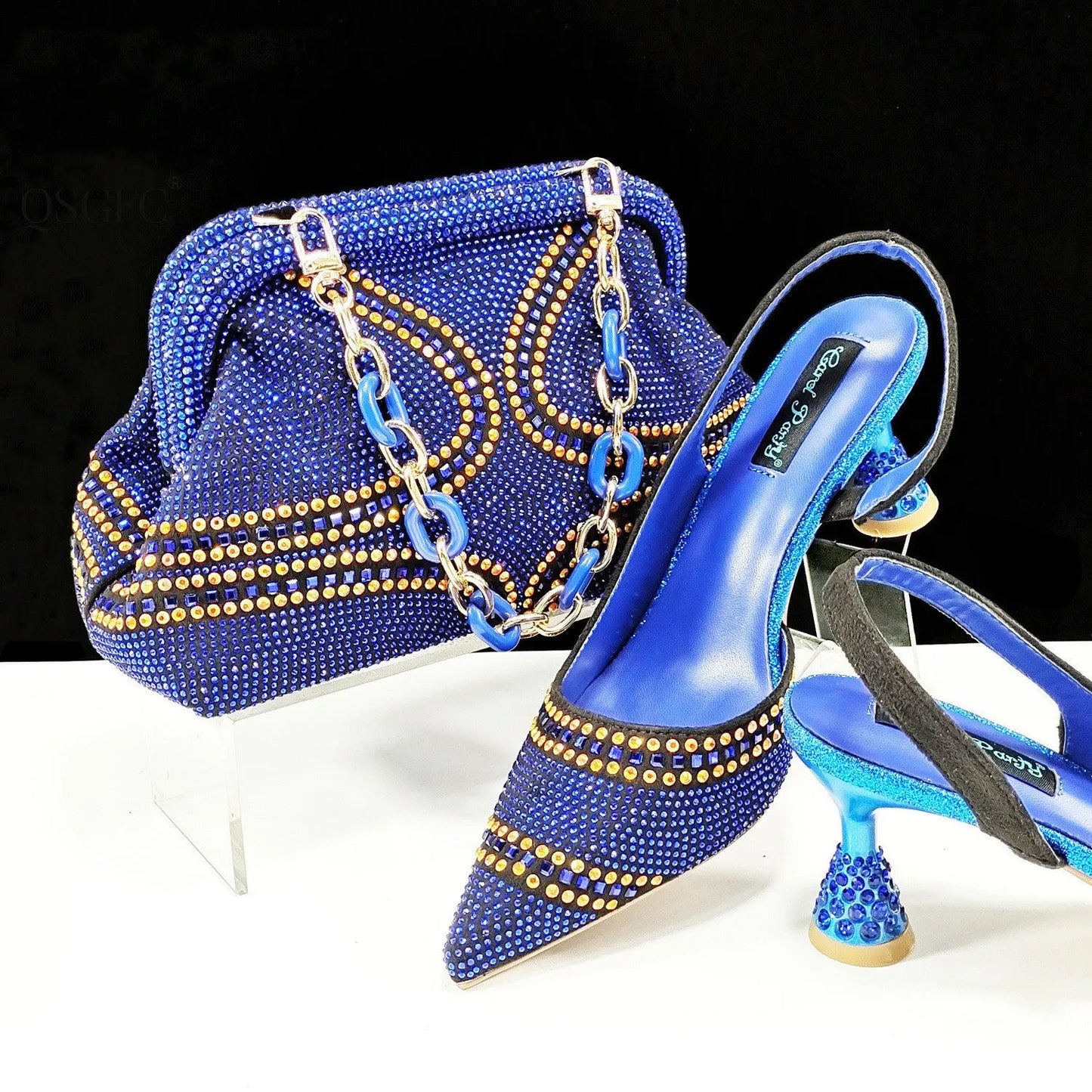 Women's pointed toe high heels with rhinestones and a matching small bag in blue.