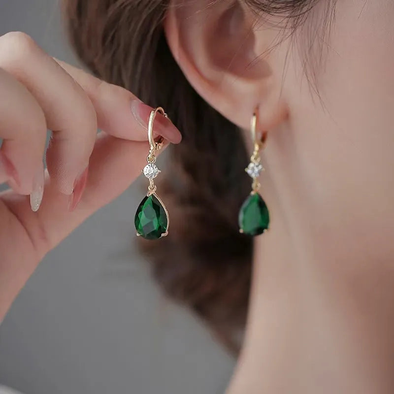 A pair of emerald green geometric teardrop drop earrings made from alloy