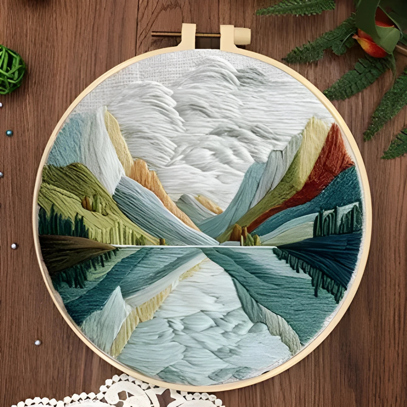 Complete DIY embroidery kit with 15cm bamboo frame, pre-printed landscape fabric, threads, and needles laid out.