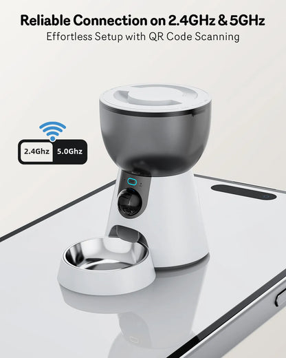 Automatic cat feeder with built-in camera on kitchen floor next to food bowl.