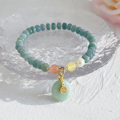 Simple blue jade bracelet with gourd charm, peace buckle, and adjustable cord on woman's wrist