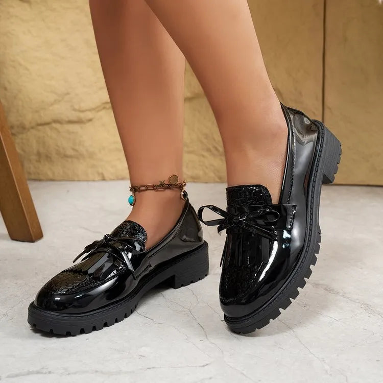 Women's brown artificial PU loafers with a bow detail on the pointed toe, shown on a size label.