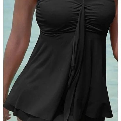 Woman wearing a strapless solid colour one-piece swimsuit or swim dress on the beach.