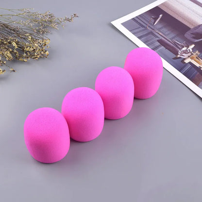 Four foam microphone wind shields in different colours for handheld stage microphones