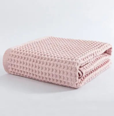 Large light-coloured cotton bath towel with a textured surface, measuring 140 by 70 centimetres.