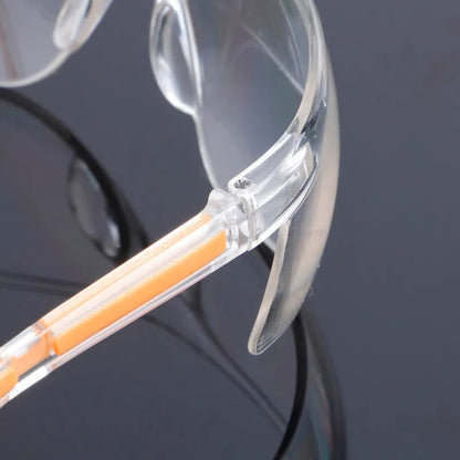 Transparent polycarbonate safety goggles with yellow frame for lab and welding protection.