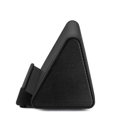 Compact black or white wireless Bluetooth speaker with charging cable.