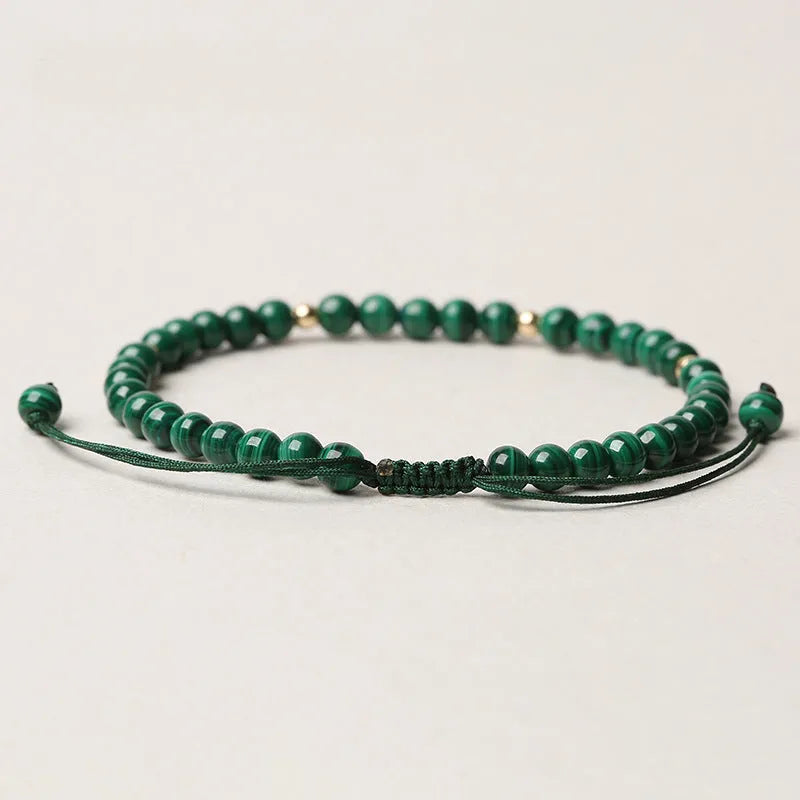 Handwoven green malachite crystal bracelet for women with golden ball accents.