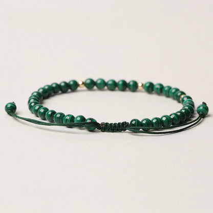 Handwoven green malachite crystal bracelet for women with golden ball accents.
