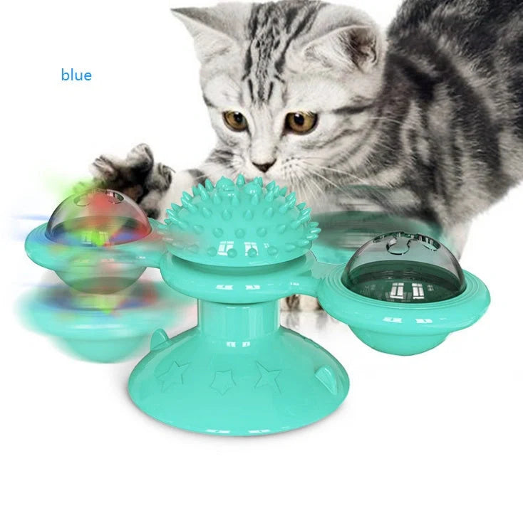 Cat playing with rotating windmill toy featuring luminous balls and suction base