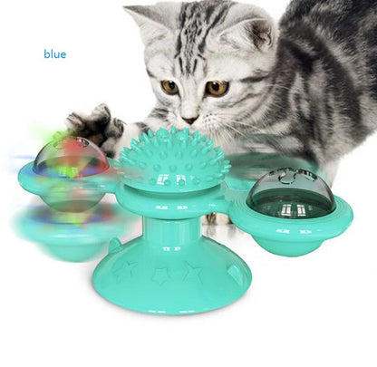 Cat playing with rotating windmill toy featuring luminous balls and suction base