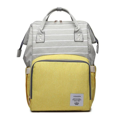 Stylish maternity diaper bag in various colors, featuring a paper bag design, separate bottle compartment, and discreet breastfeeding button.