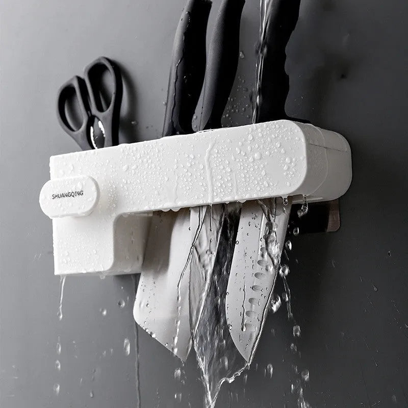 White modern plastic knife block holding six kitchen knives on a countertop.