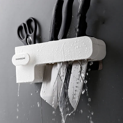 White modern plastic knife block holding six kitchen knives on a countertop.