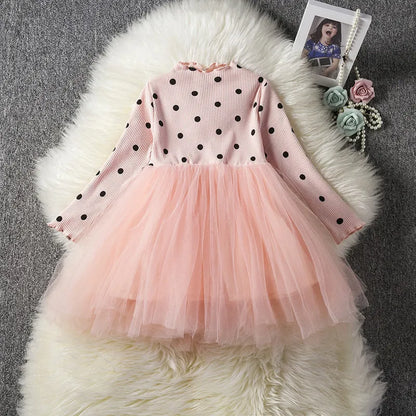 Baby girl wearing a long sleeve black tutu dress with lace detail for a birthday party.