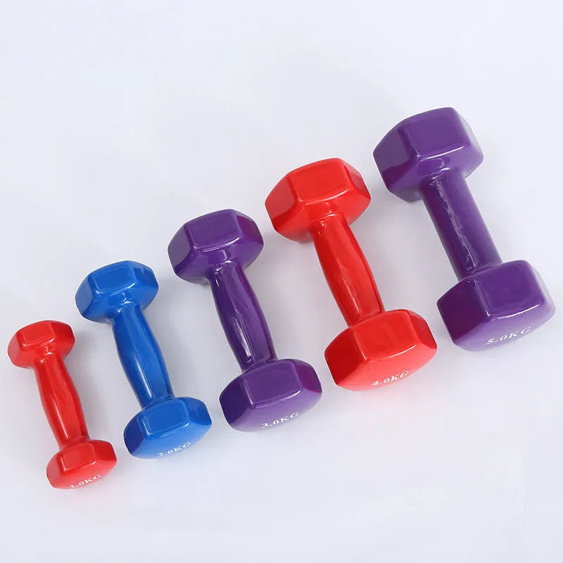 Set of bright coloured plastic-coated fitness dumbbells in 0.5kg, 1kg, and 1.5kg weights on a floor.
