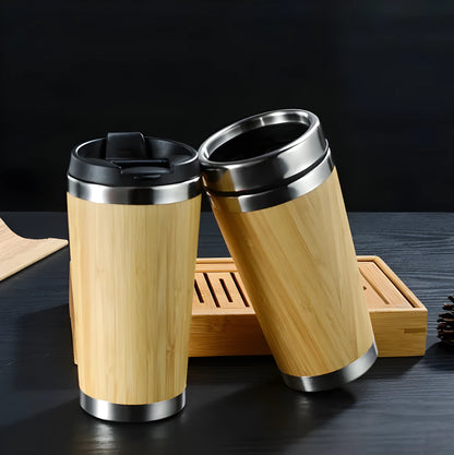 Natural bamboo fibre and stainless steel reusable travel coffee cup with black leak-proof lid on a table