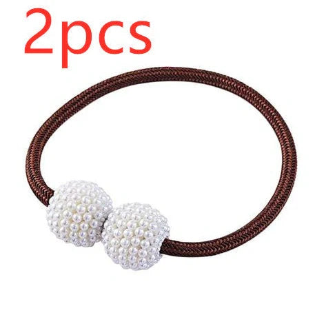 Magnetic curtain tiebacks with white pearl beads and fabric loops holding gathered curtain