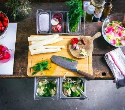 A multifunctional bamboo cutting board with integrated storage trays for efficient and organized meal prep