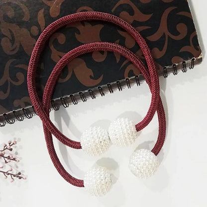 Magnetic curtain tiebacks with white pearl beads and fabric loops holding gathered curtain