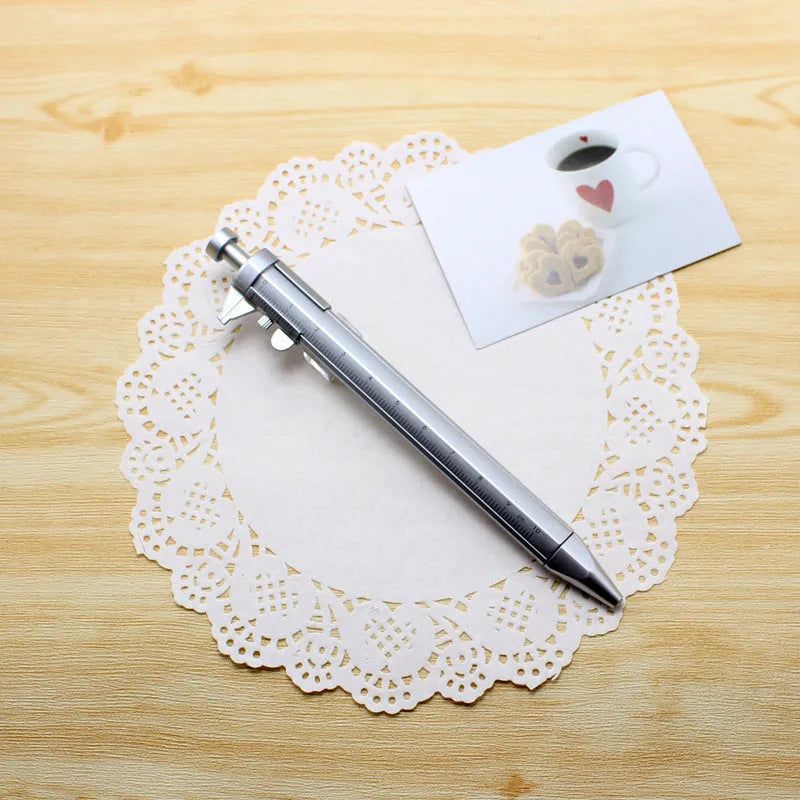 Orange multifunction ballpoint pen with integrated silver slide caliper, showing 15cm length and 0.5mm tip.