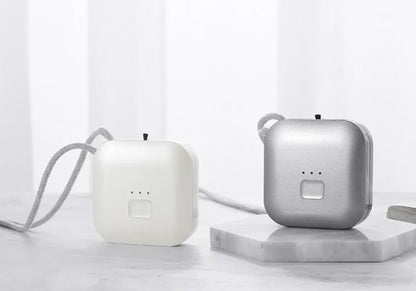 Compact pink USB air purifier necklace on a table with charging cable, showing dimensions 1.5 by 5.7 cm.