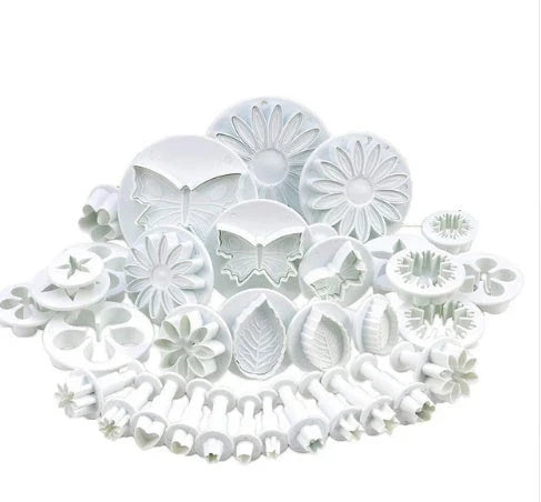 Assortment of cake decorating tools including plungers and knives in various floral designs