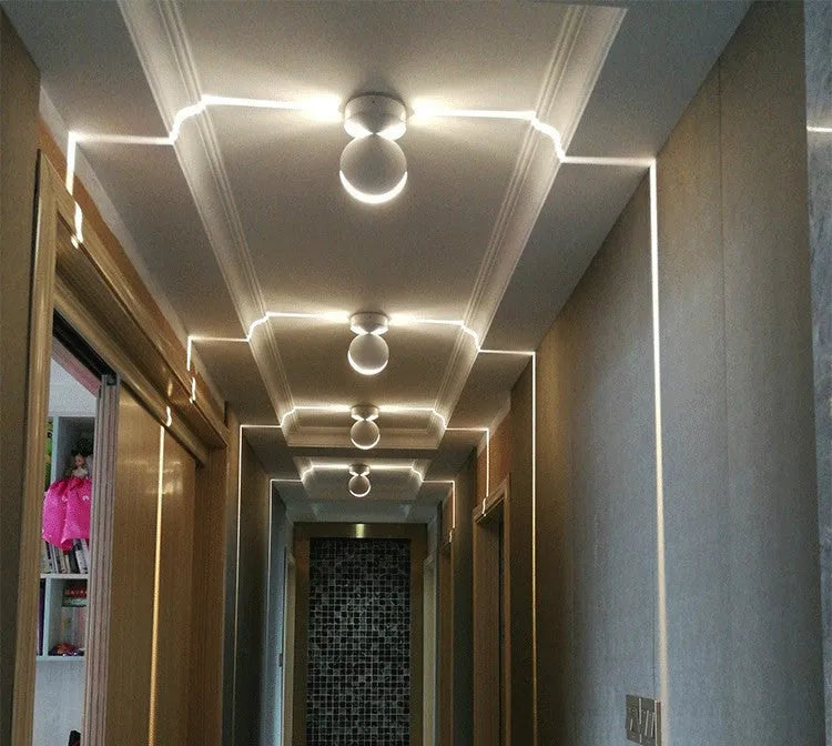 Modern linear aluminium wall spotlight bar with a glass lens, mounted as an accent light.