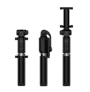 Aluminium tripod selfie stick with extended phone clip and Bluetooth remote on a table
