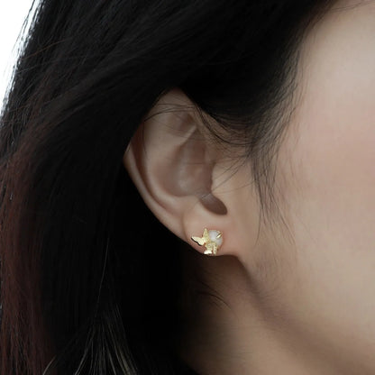 Close-up of a pair of 925 silver butterfly ear studs with gold plating, showing detailed animal zodiac modelling.
