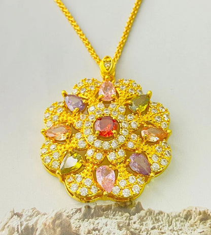 Close-up of a women's flower-shaped pendant necklace with a colourful zircon stone in a choice of gold, champagne gold, or platinum colour finishes.