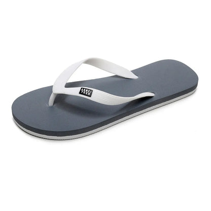 Men's black flip-flop slippers with EVA upper and textured rubber sole on a sandy background.