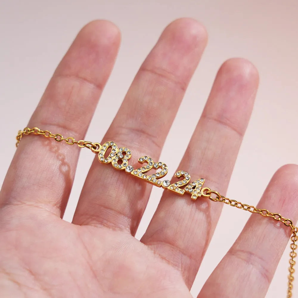 Stainless steel digital bracelet with diamond-set numbers on a wrist, showing gold, rose gold, and steel colour options.