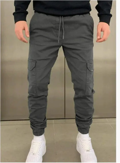 Men's light blue polyester loose-fit straight-leg trousers with dimensional patch pockets and elastic waistband laid flat.