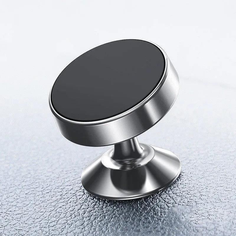 Silver aluminium alloy magnetic car phone holder with rotating ball head mounted on a car air vent.
