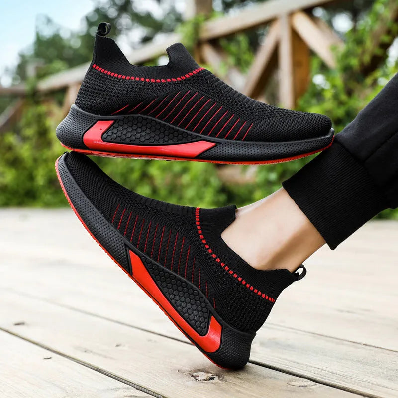 Men's black and white striped slip-on sneakers with lace-up front and mesh upper.