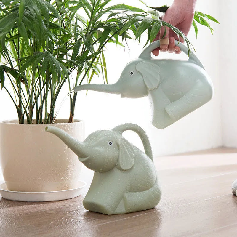 A pink children's elephant-shaped watering can with a long nozzle and baby bottle handle for gardening.