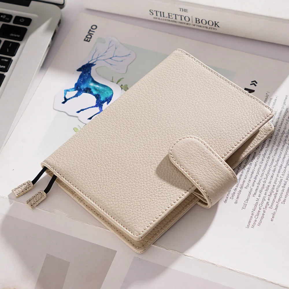 Close-up of a hand-embossed lychee pattern on an off-white A6 cowhide leather notebook with loose-leaf binding.