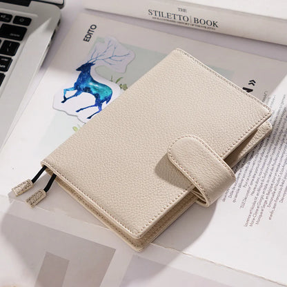 Close-up of a hand-embossed lychee pattern on an off-white A6 cowhide leather notebook with loose-leaf binding.