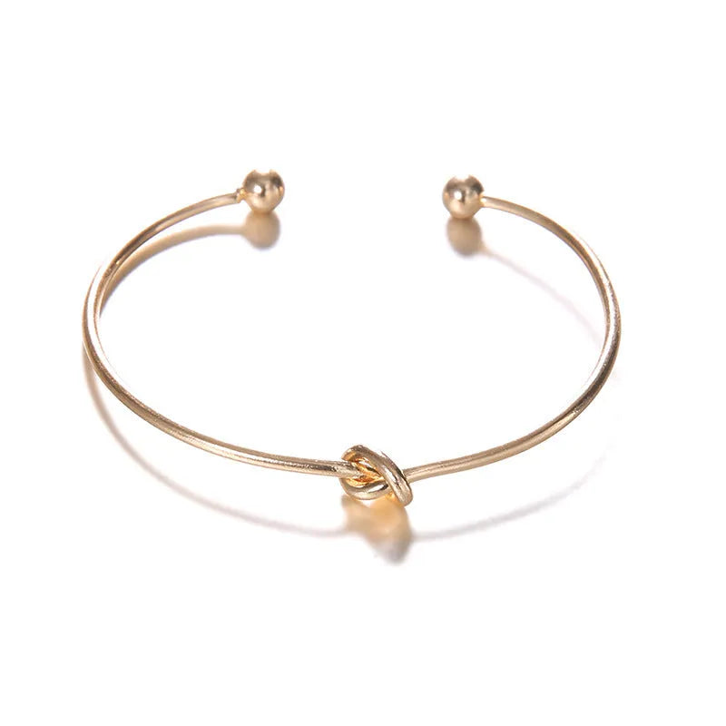 Gold-coloured vintage arrow knotted cuff bracelet for women.