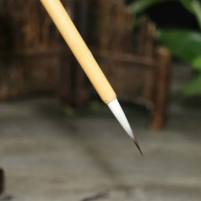 Four traditional writing brushes with gold bodies, wolf wool hair, and pine branch colour