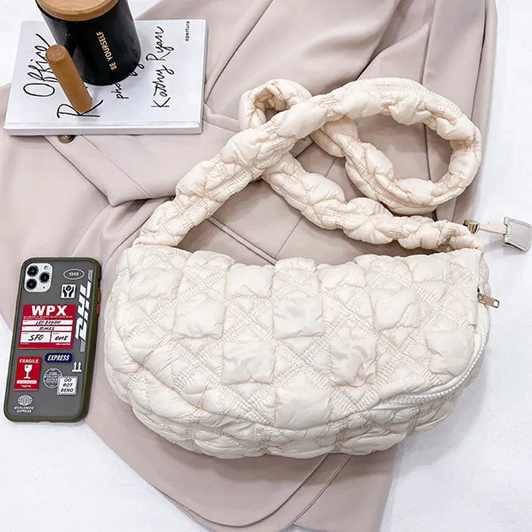 Women's light grey nylon underarm messenger bag with adjustable long strap, shown worn crossbody.