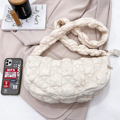 Women's light grey nylon underarm messenger bag with adjustable long strap, shown worn crossbody.