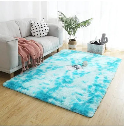Soft fluffy plain rectangle carpet with anti-slip dots on backing, shown in a light grey colour on a wooden floor.