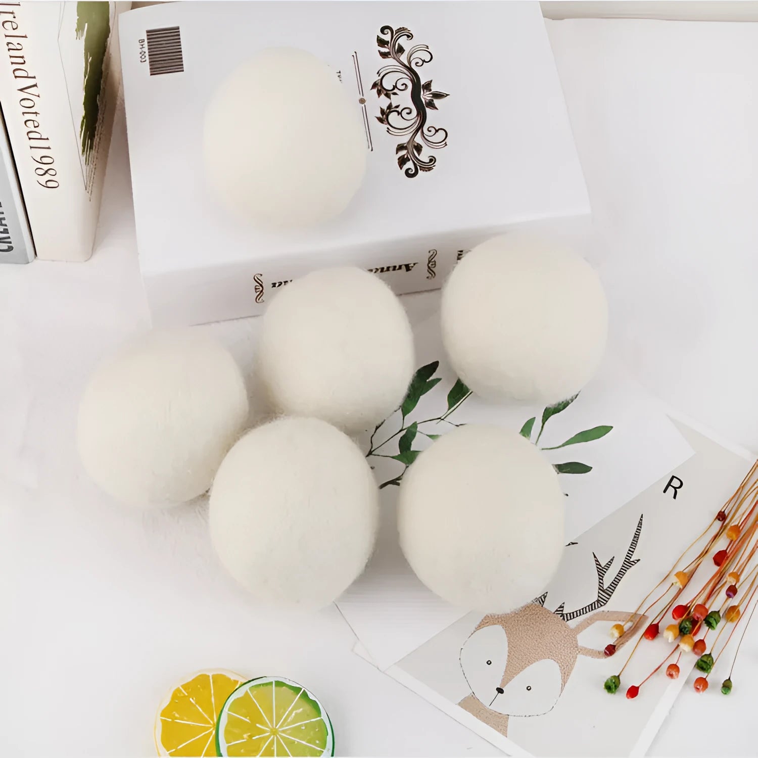 A 100% wool drying ball for laundry next to a plain cotton storage bag on a background.