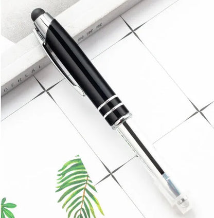 Red metal multifunctional stylus ballpoint pen with LED light on a desk.