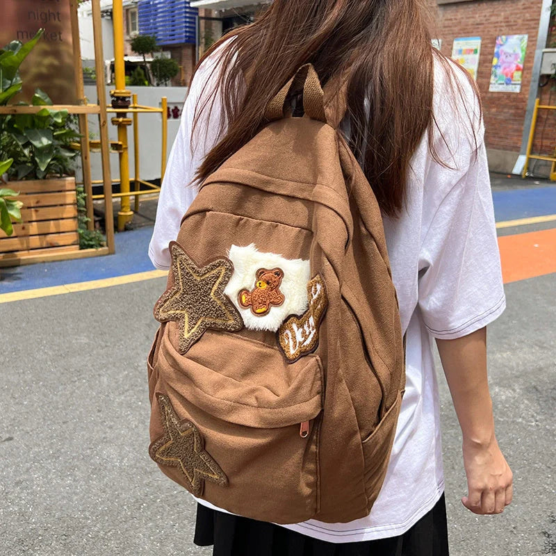 Brown canvas backpack with geometric patterns, ideal for female college students