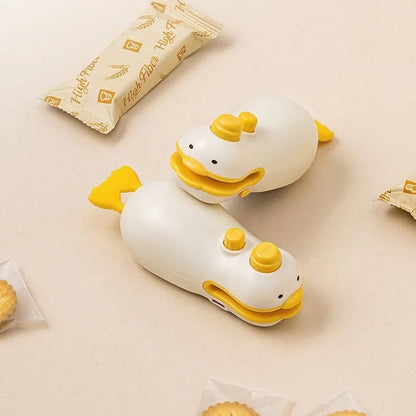 Small yellow duck shaped rechargeable handheld sealing machine with USB cable.