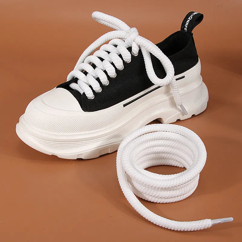 Round woven white, beige, and black shoelaces for bread shoes showing different lengths on a flat surface.