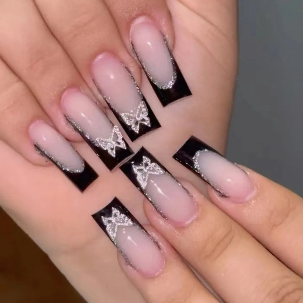 Black French style butterfly nail armour set with glitter decoration on medium-length nails
